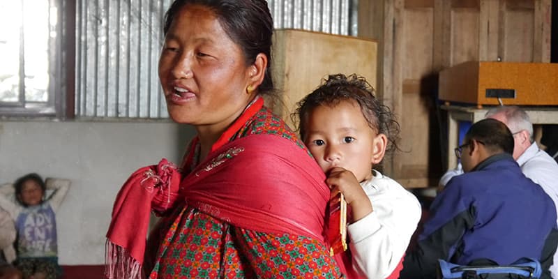 Nepal Mutter mit Baby auf dem Rücken